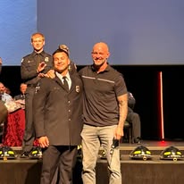 CFA members hired and honored on stage in firefighter dress uniforms